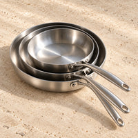 Pack Apprenti LAEVOR : les trois poêles inox 316 sur un plan de travail en travertin